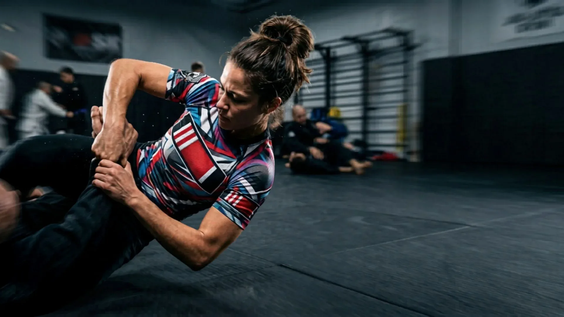 Athlete in a sublimated rash guard training on the mats