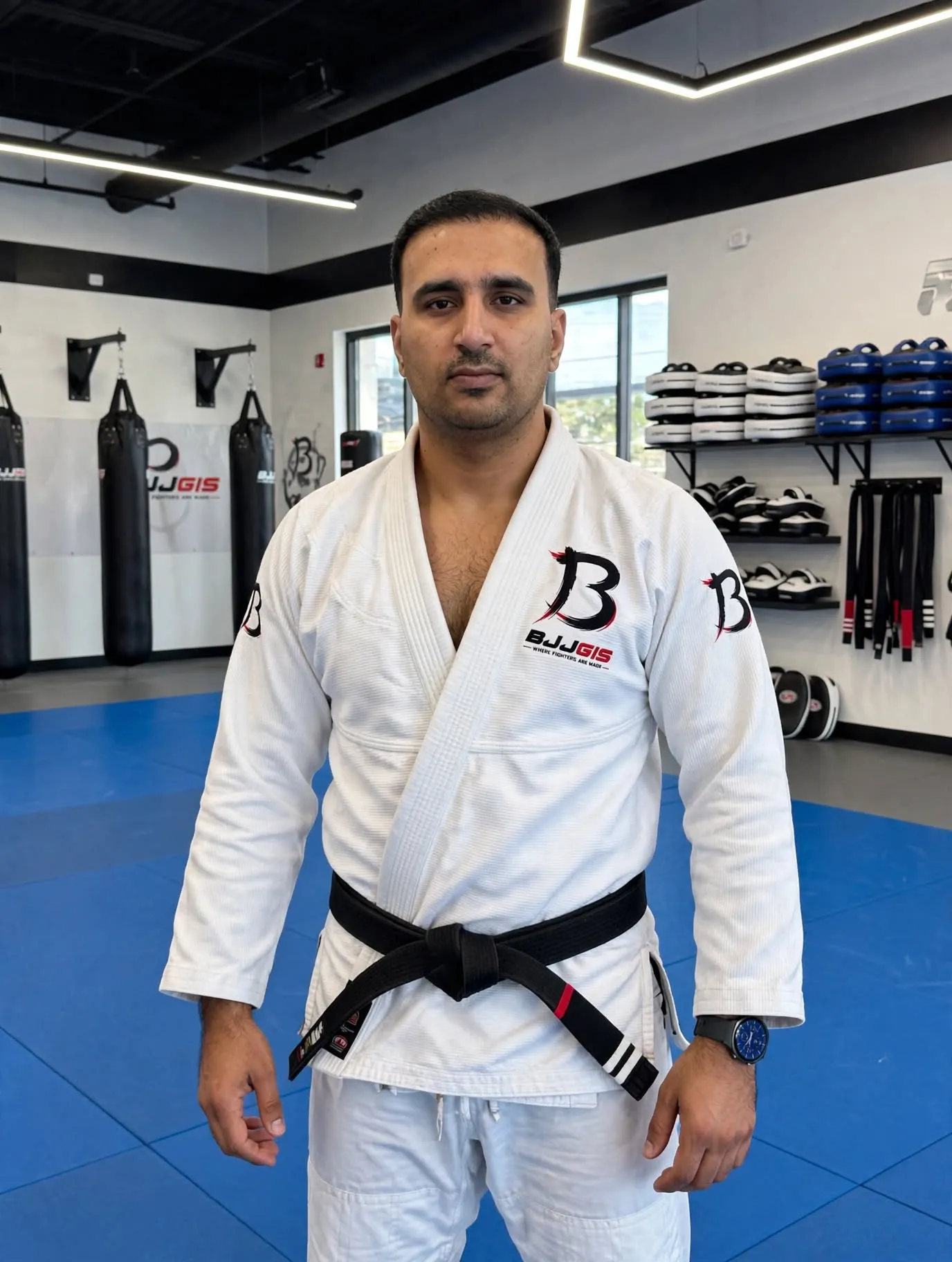 Martial artist in a Gi seated on the mat