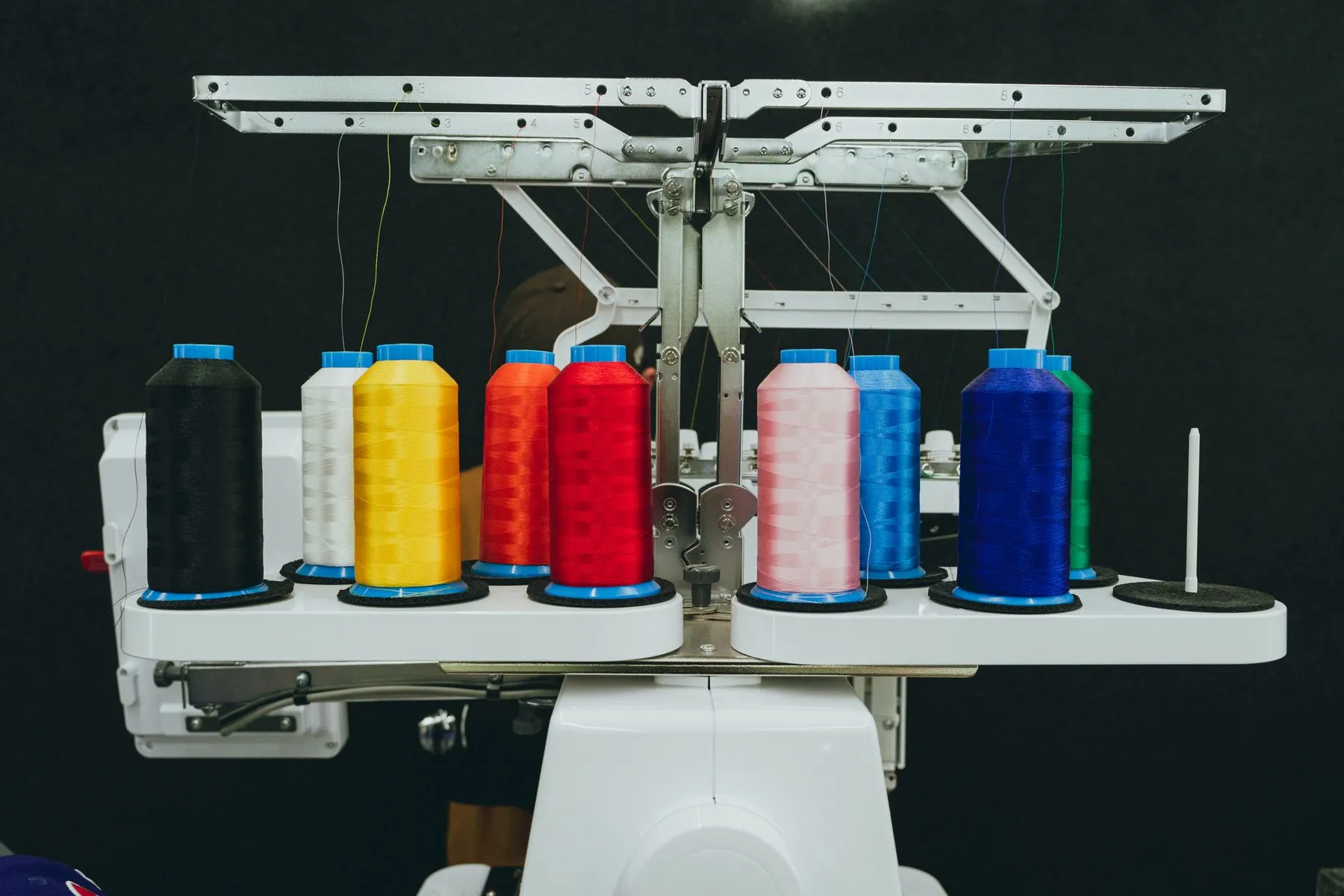 Colourful thread spools on an embroidery machine