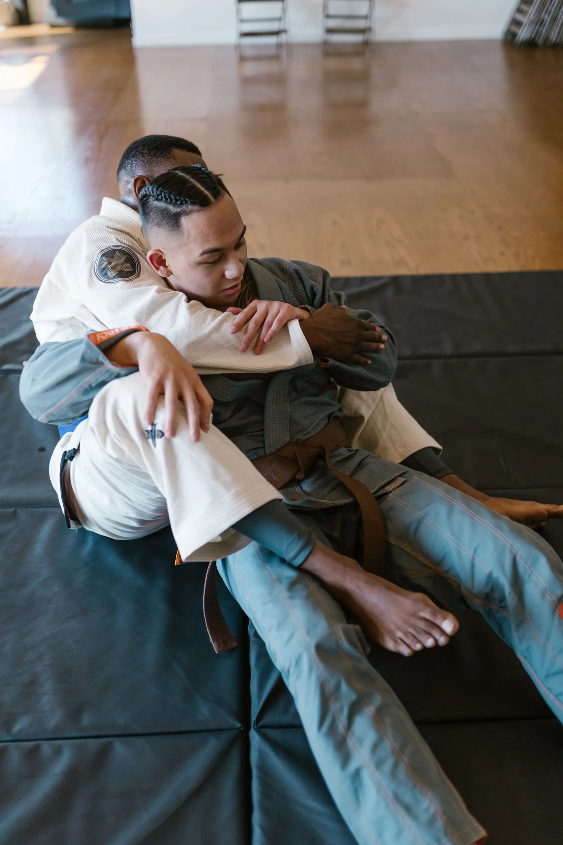 Two athletes grappling in shorts and spats