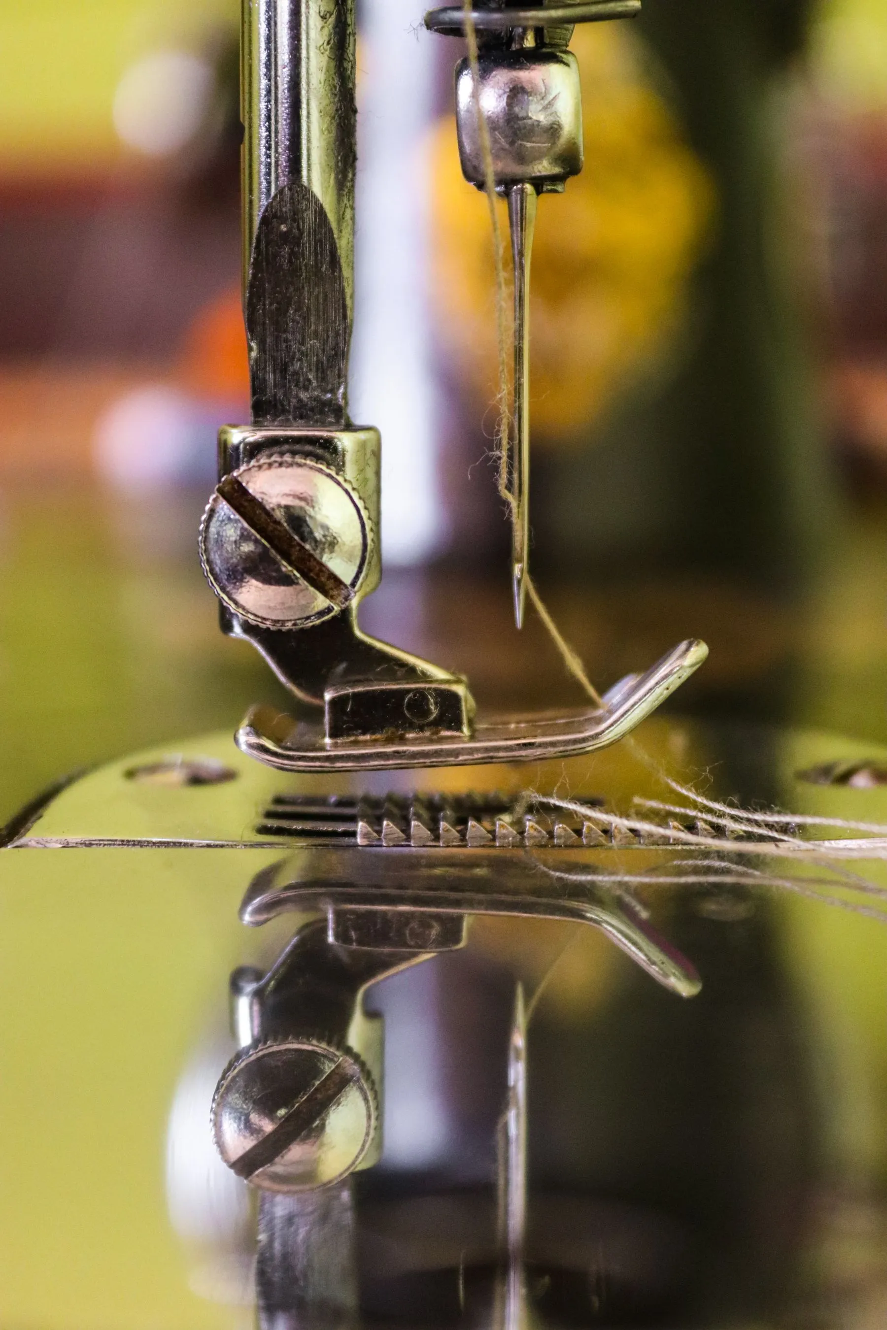 Macro of a sewing machine needle stitching cloth
