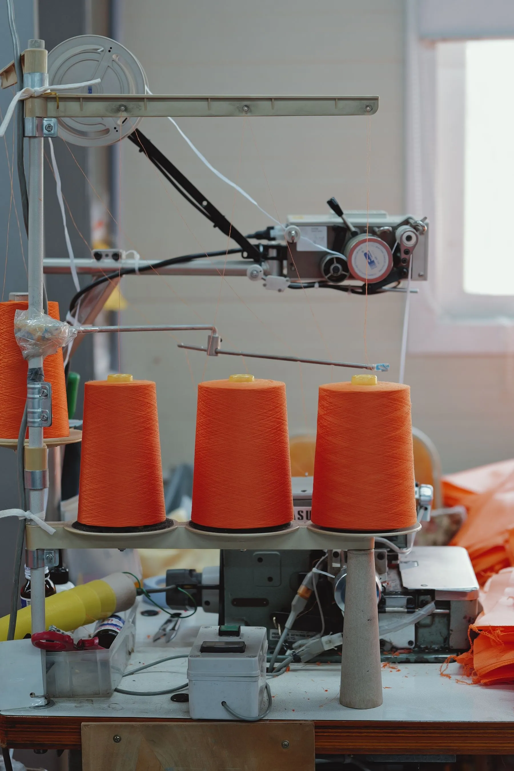 Orange yarn spools on textile machinery