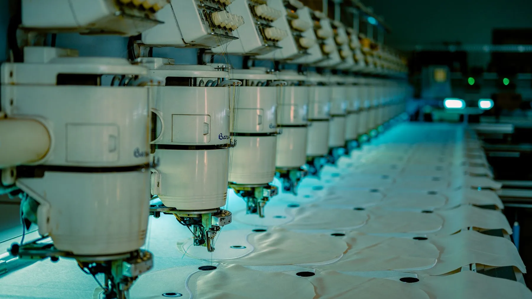 Row of industrial sewing machines on a garment production floor