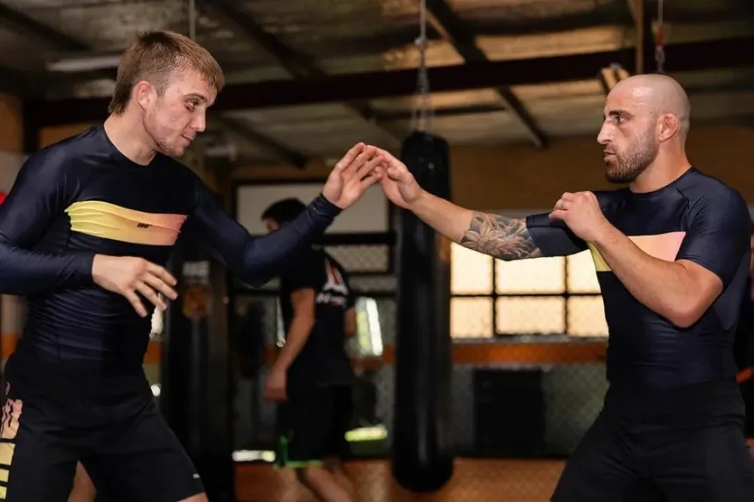 Two athletes sparring in no-gi rash guards in the gym